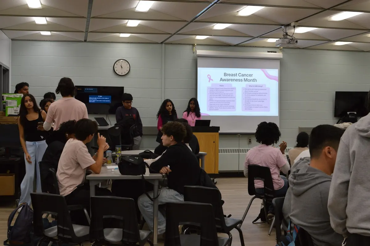The Breast Cancer Awareness Month title slide in front of a room of students