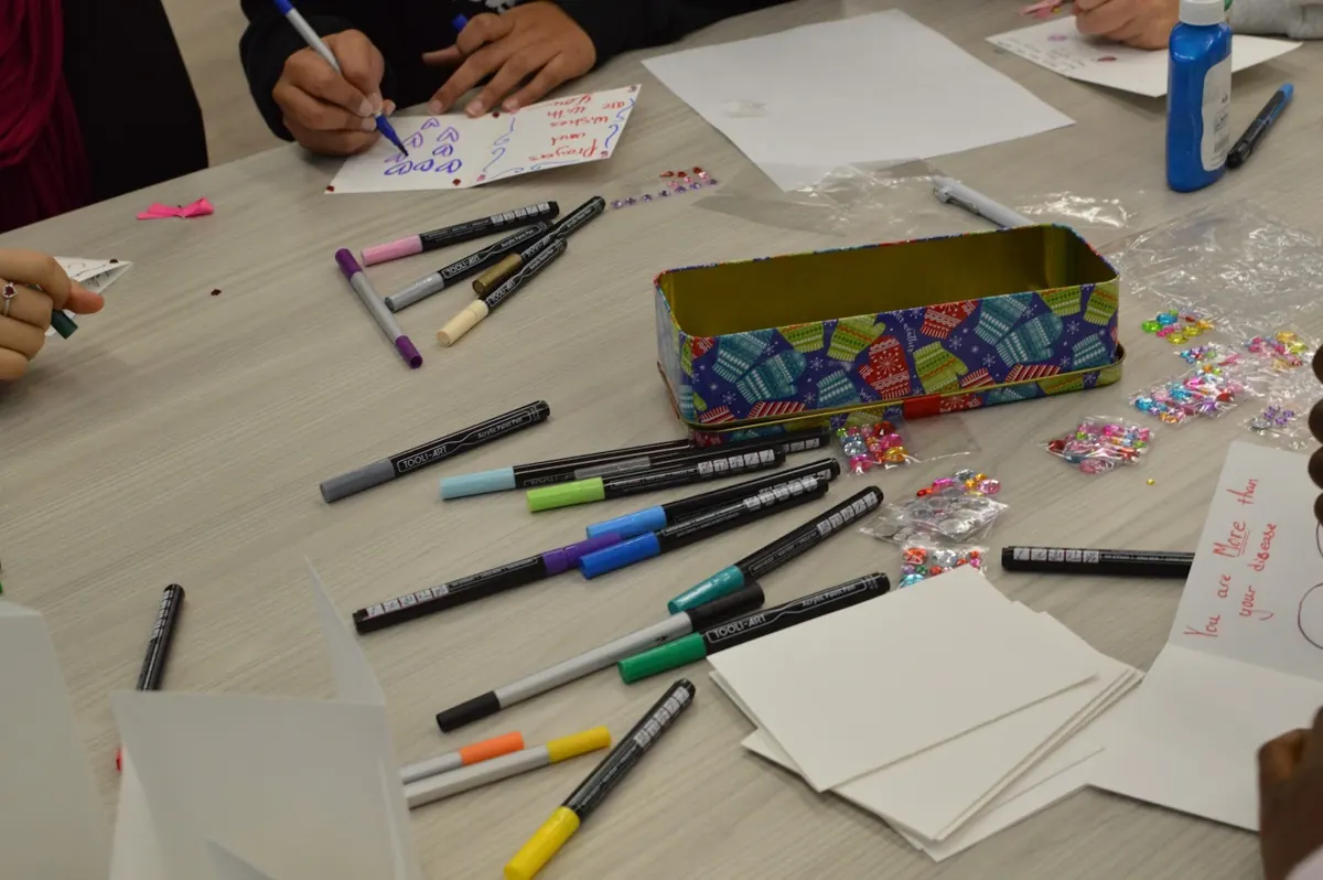 Markers, glue and blank cards spread across a craft table