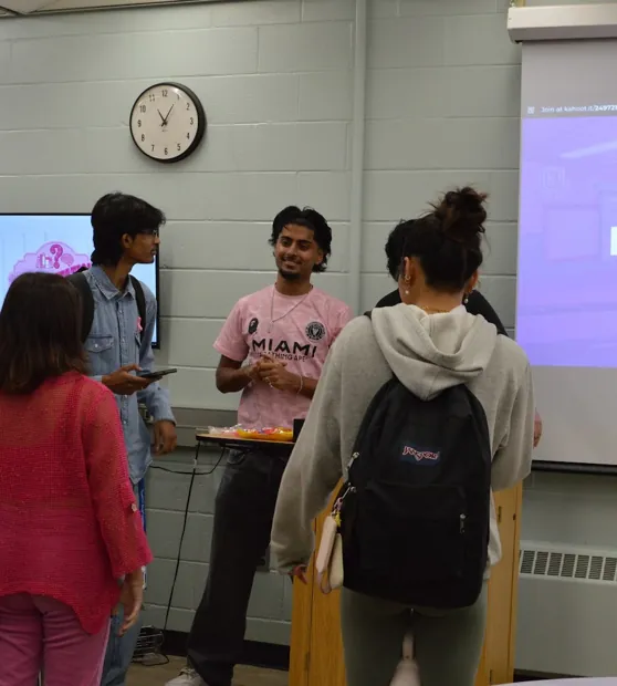 Students gathered around an FHI volunteer between activities