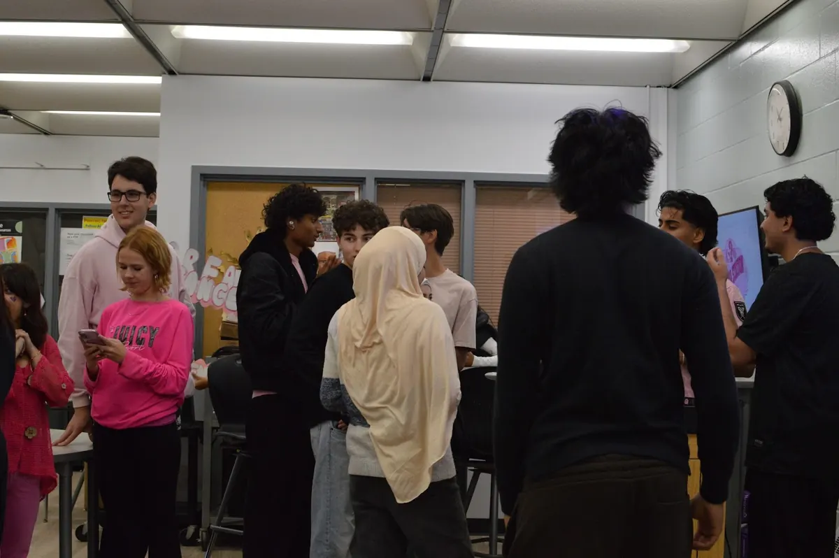 Students crowding toward the screen for the closing quiz